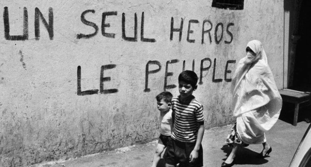 Alger, années 1960 : enfants devant le mur « Un seul héros, le peuple »